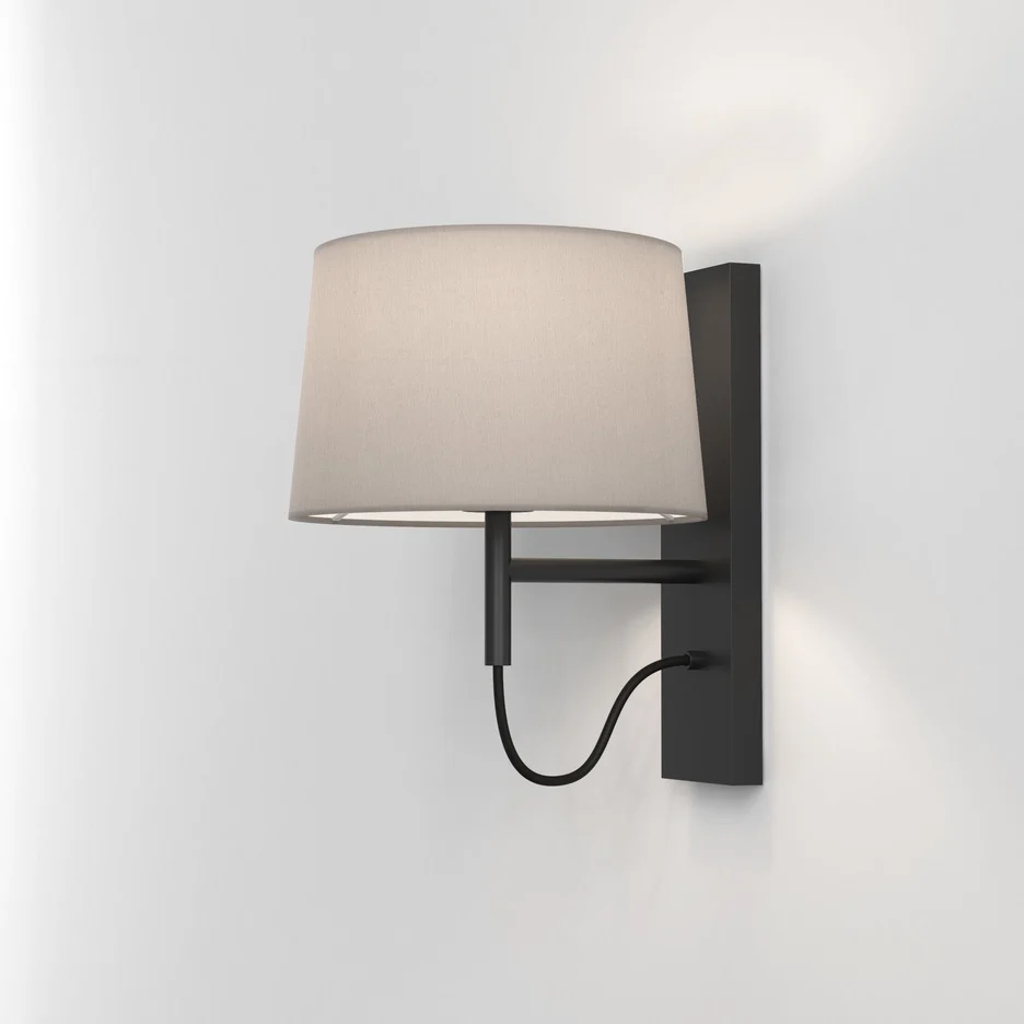 The Telegraph wall light features a sleek, modern design with an angled arm and rectangular backplate in a matt black finish. Available with a tapered shade in four colours: white, black, putty, and mocha.