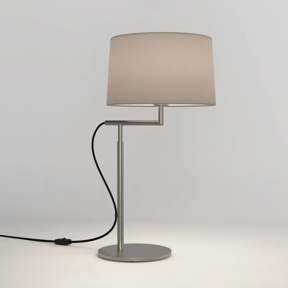 The Telegraph table light features a sleek, modern design with an angled arm and round base in a matt nickel finish. Available with a tapered shade in four colours: white, black, putty, and mocha.