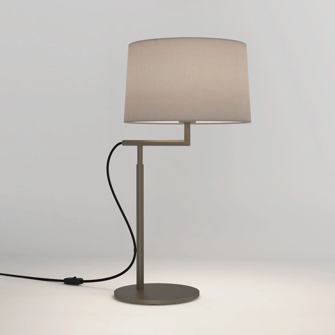 The Telegraph table light features a sleek, modern design with an angled arm and round base in a bronze finish. Available with a tapered shade in four colours: white, black, putty, and mocha.