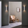 The Shadow wall light is a modern, cylindrical shaped downlight in a white plaster finish which can be painted to any desired colour. Shows two 300mm style lights installed in a hall.