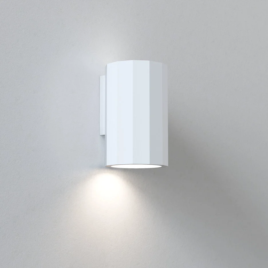 The Shadow wall light is a modern, cylindrical shaped downlight in a white plaster finish which can be painted to any desired colour.