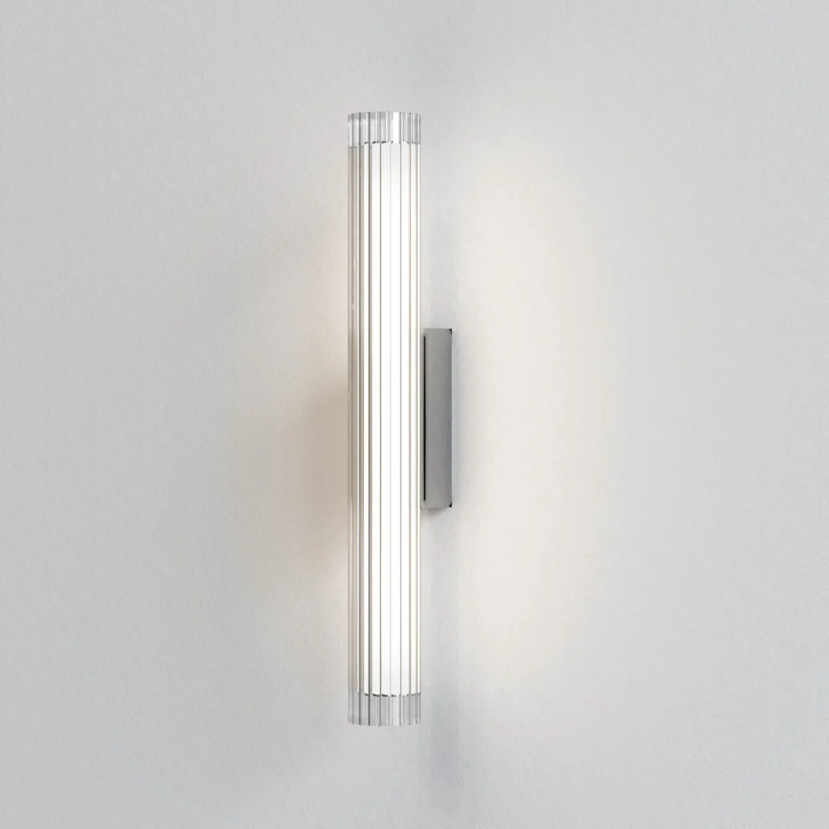 The io wall light features a modern cylindrical design with ribbed glass in a polished chrome finish. IP44 rated and safe for use and bathrooms.