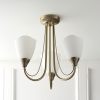 Shows the Haughton ceiling light installed in a room and turned off. The light features 3 arched arms finished in antique brass, complete with opal glass shades.
