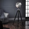 Shows the Nautical floor light in a room. The light features a tripod design with matt black stained wooden legs and a nautical style lamp head in a polished nickel finish. The lamp is adjustable 360° and the legs are also height adjustable. Complete with inline foot switch and 1.8m black cable.