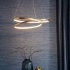 Shows the Scribble pendant light in a room. The pendant features a single, continuous looping ring in a beautiful gold leaf finish with integrated 33w LED.