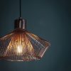 Close up of the Kimberley pendant light which features an elegant industrial design with a metal wire shade finished in polished copper plate.