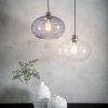 Shows both variations of the Dimitri pendant shade, clear and grey glass in a room with a light background.