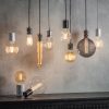 Shows various cable set pendants with stylish filament bulbs alongside similarly styled table lamps from the Endon Lighting range.