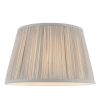 The Freya lampshade features gathered pleated silk in silver with a matching taped edge, pale ivory inner lining, and a reversible gimbal allowing the shade to be used as a table or pendant light.