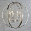 The Ritz pendant light features a highly polished bright nickel metalwork, encrusted with thousands of clear faceted reflective details. The spherical cage encloses 6 lamps. Shows the pendant against a grey backdrop.