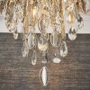 Close up of the bottom of the Melody ceiling light and the hanging crystal glass beads and teardrops alongside chrome, leaf shaped details enclosing 6 lamps.