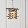 Close up of the Daya pendant light hanging in a white panelled room.
