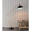 The Marshall floor light features a beautiful and highly adjustable design in a bronze finish with satin black detailing. Complete with inline foot switch. Shows the floor light in a room shining light on a table.