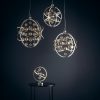 Shows the Muni product range in chrome. The pendants and table light all feature a striking spherical design with metal arms in chrome. A mix of chrome and clear spheres hang from the fittings at various heights.