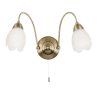 The Petal wall light features two arching arms in an antique brass finish, each complete with frosted glass flower shaped shades.