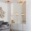 Shows two three lamp hoop ceiling lights installed in a living room with three hoop floor lights. The ceiling lights have brushed brass and copper finishes. The floor lights have brushed nickel, brass, and copper finishes.