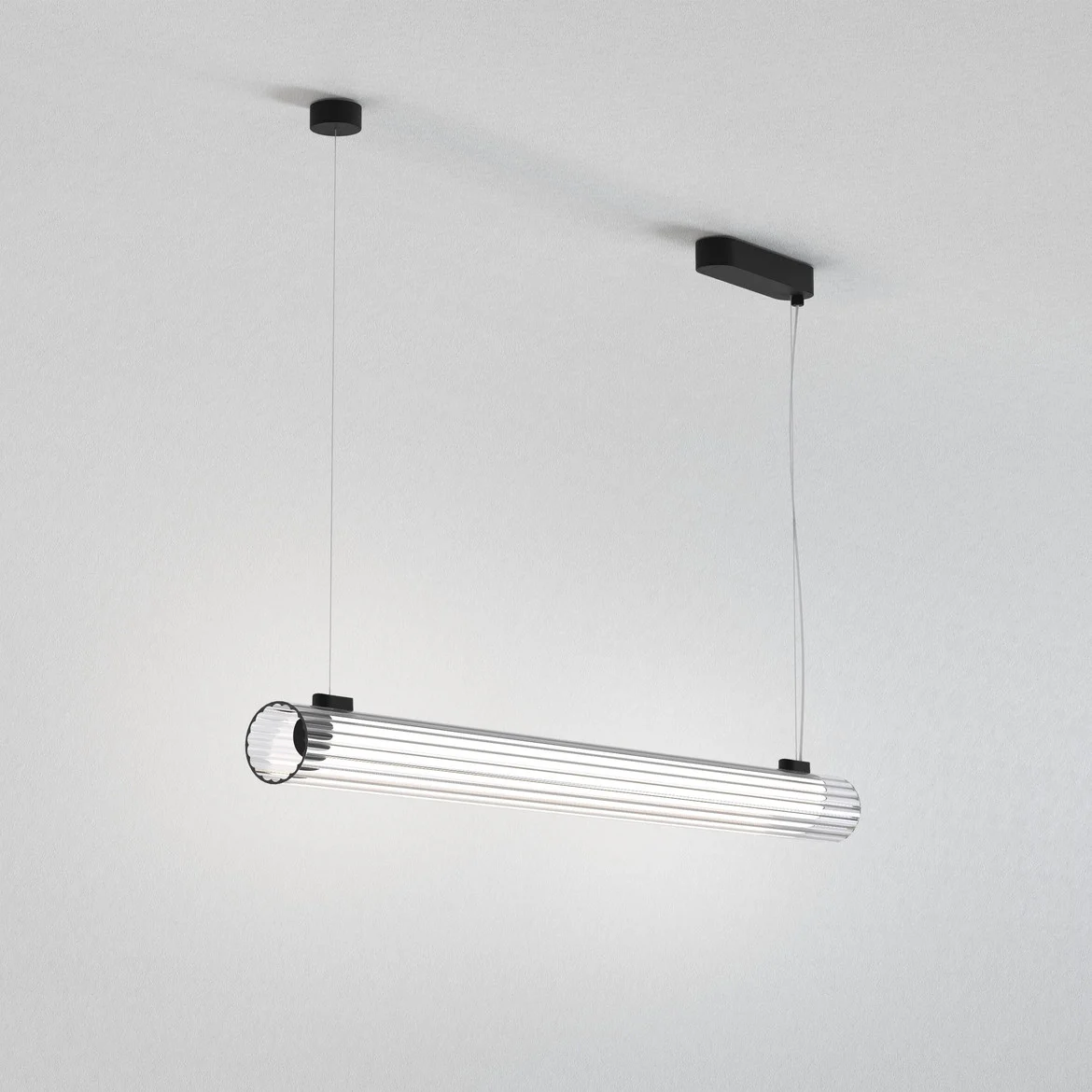The io pendant light features a modern cylindrical design with ribbed glass and detailing in a matt black finish.
