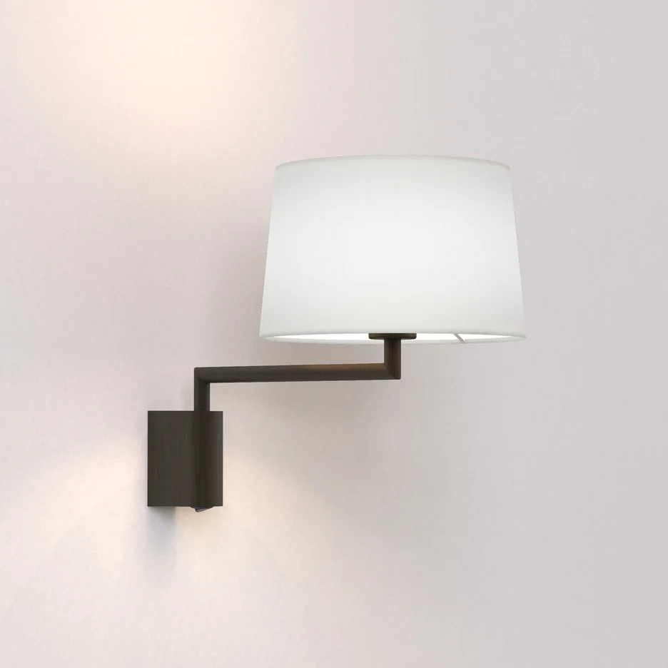 The Telegraph Swing wall light features a sleek, modern design with an angled arm and adjustable positioning in a bronze finish. Available with a tapered shade in four colours: white, black, putty, and mocha.